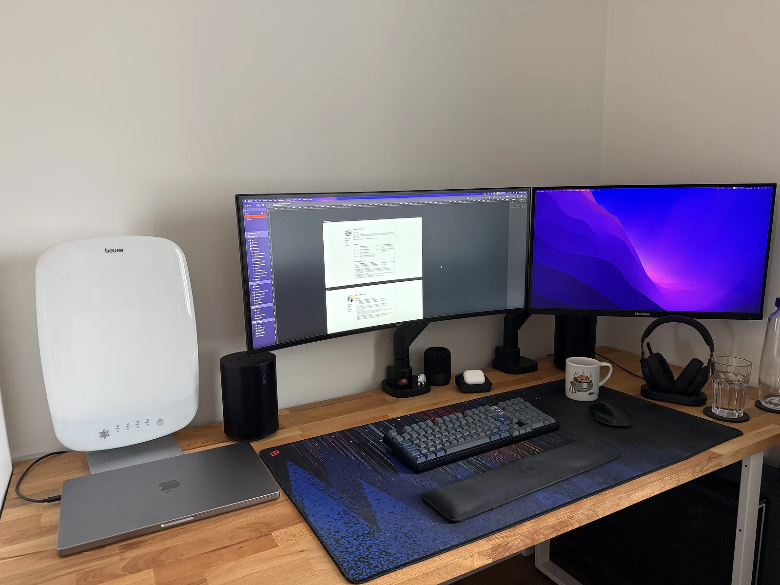 wooden desk with two monitors, keyboard laptop and desktop computer